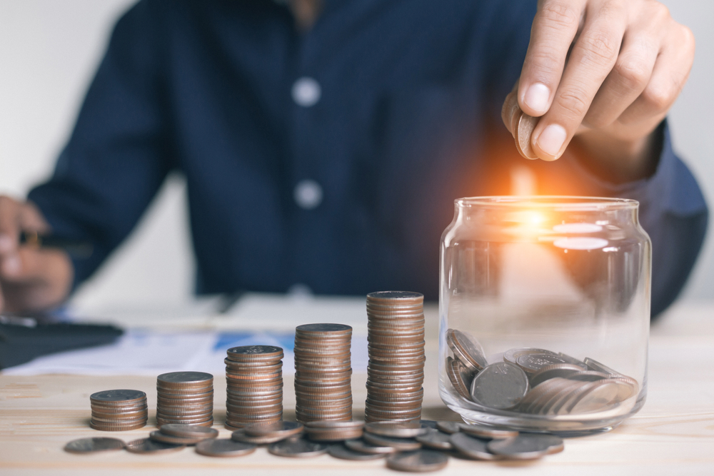 Businessman,Holding,Coins,Putting,In,Glass.,Concept,Saving,Money,For