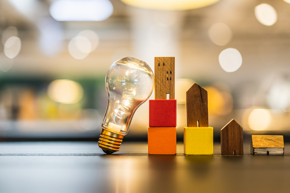 Light,Bulb,With,Wood,House,On,The,Table,,A,Symbol