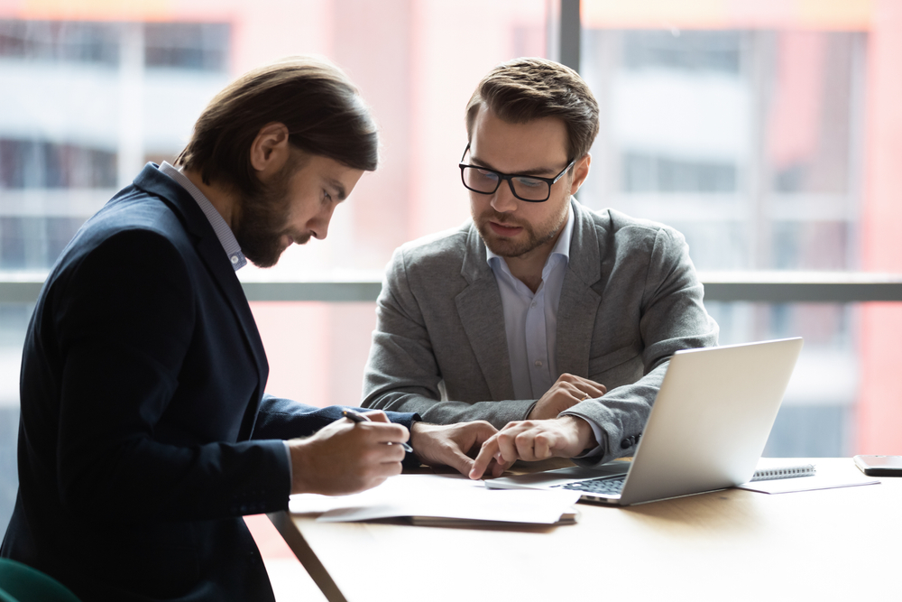 Focused,Young,Businessman,Signing,Agreement,With,Skilled,Lawyer,In,Eyeglasses.