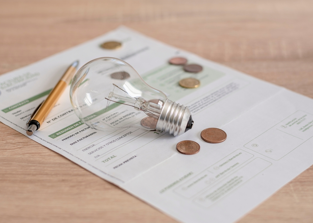 Electricity,Bill,With,Light,Bulb,,Several,Coins,And,Pen,On